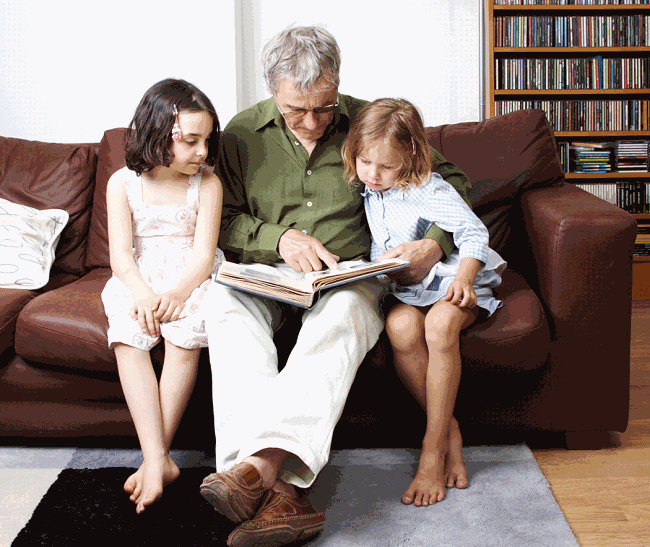 дедушка и внучки читают книгу